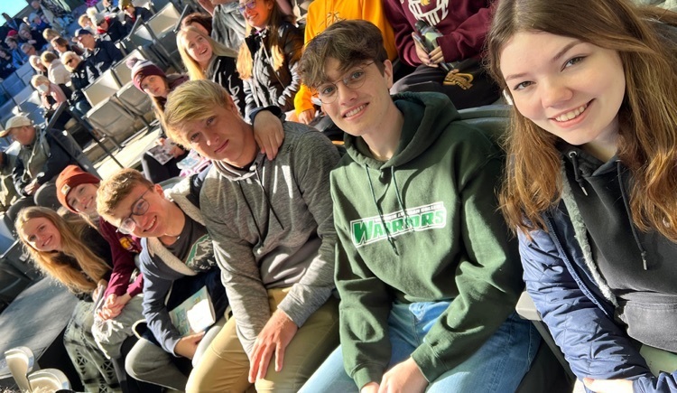 senior students sit in a row in the outdoor theater