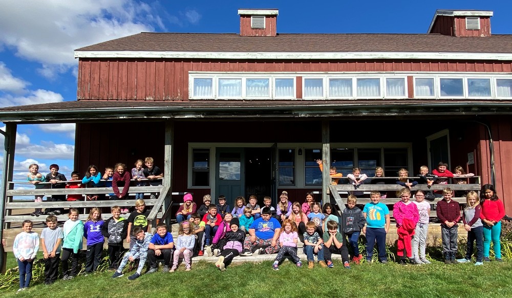 all 3rd grade students pose for a picture out in front of Folklore Village building