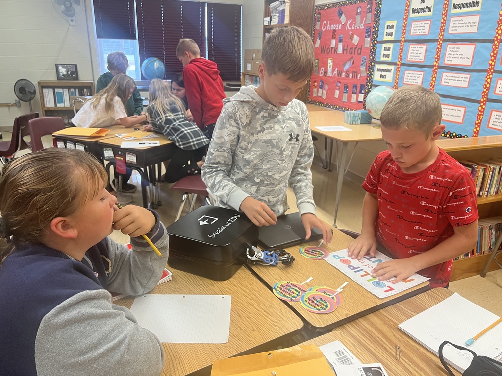 Students  sit in a group and work together to solve a puzzle.